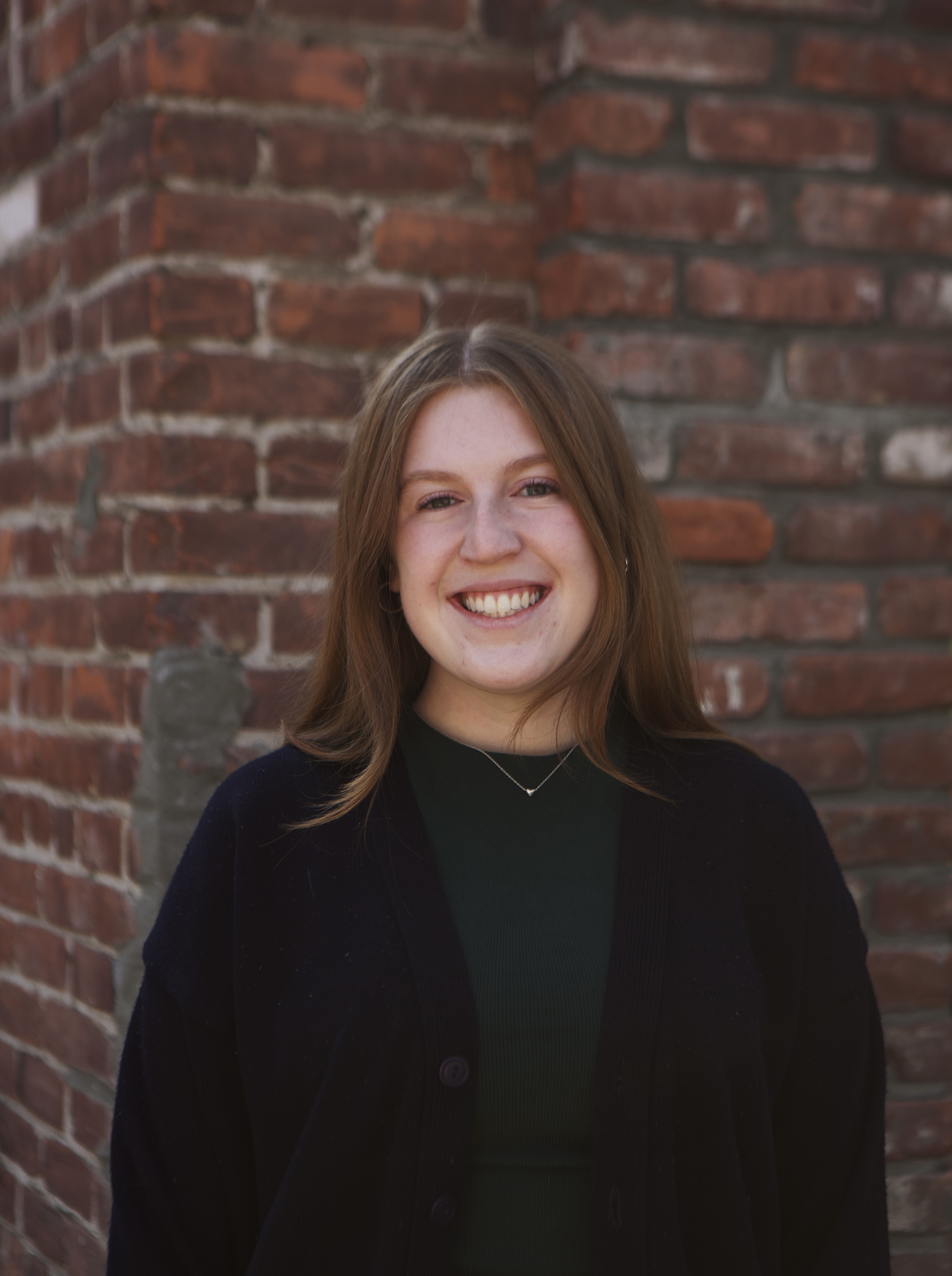 Headshot of Emma Kaisner in front of brick wall